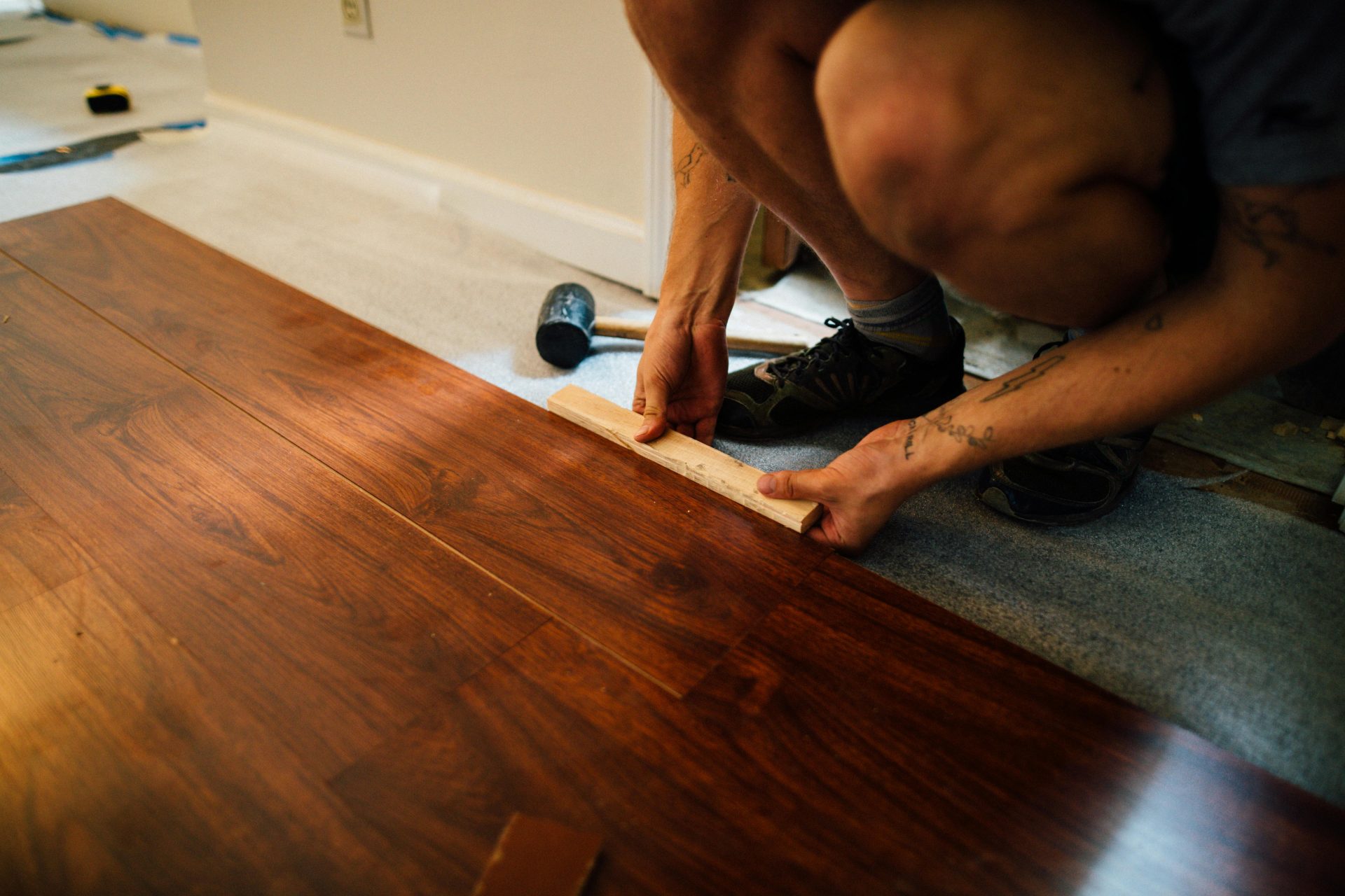Installing wooden flooring over subfloor in room.