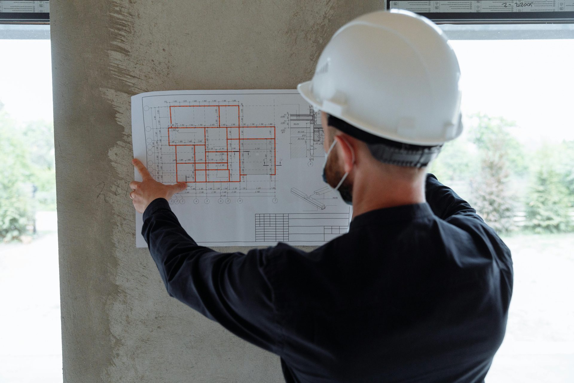 Construction worker reviewing floor plan diagram.