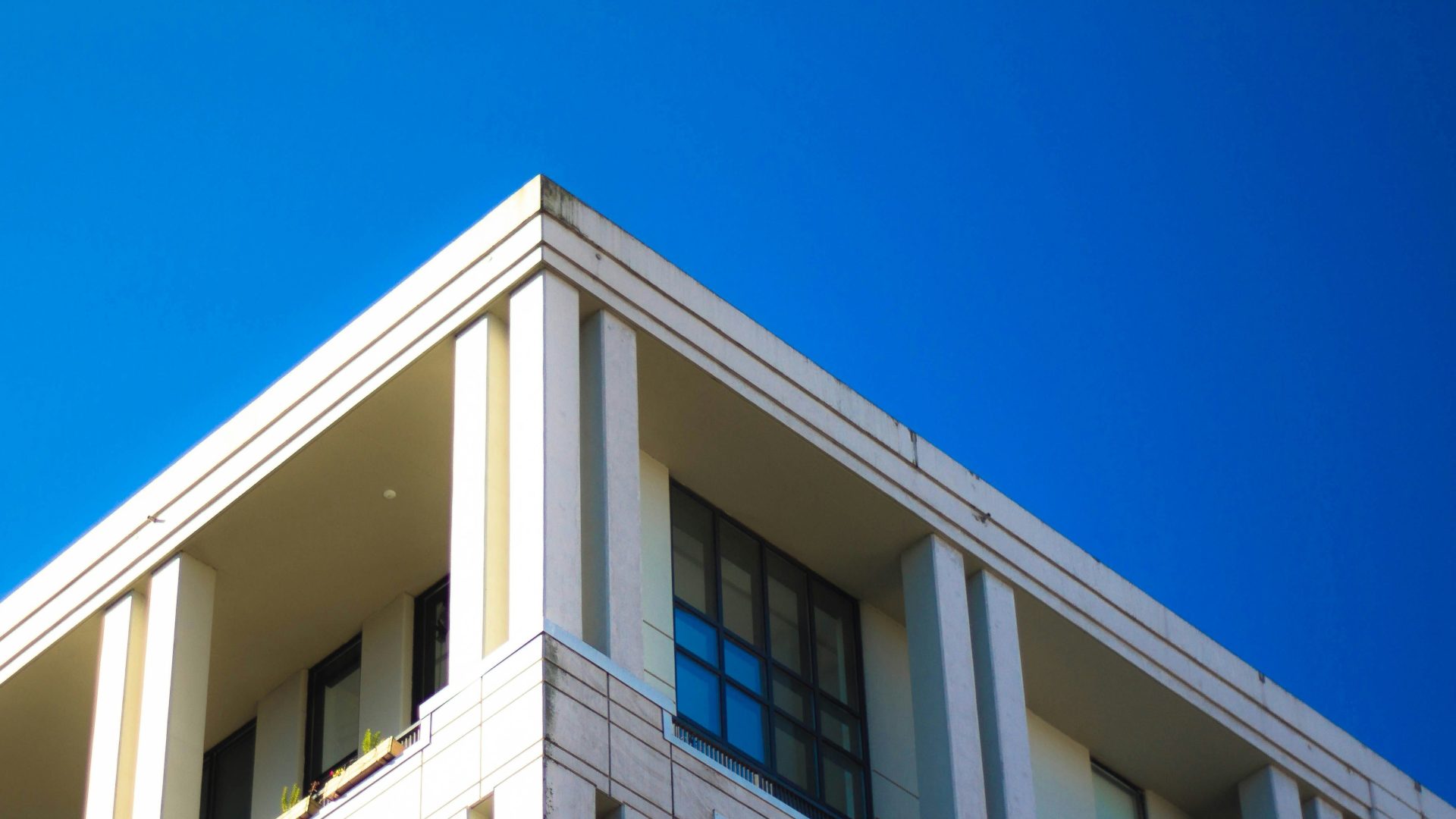 Corner of a modern building against a vibrant blue sky